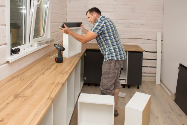 Furniture assembler assembles kitchen furniture in a private house