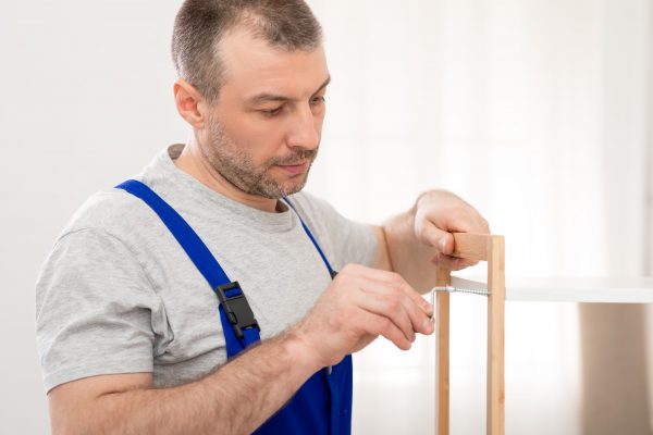 Professional Carpenter Assembling Furniture Tightening Screws Fixing Shelf Indoors